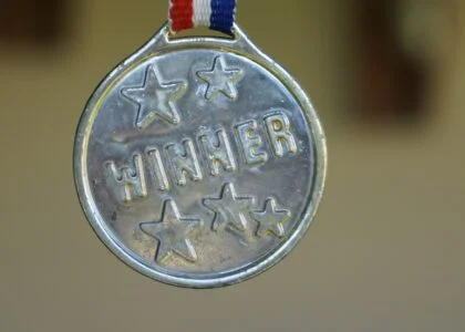gold medal on red white and blue ribbon with the word winner engraved
